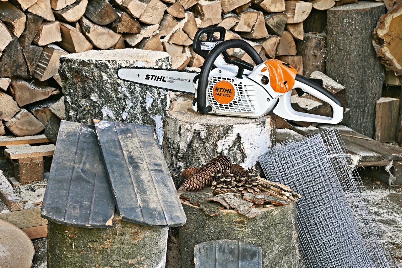Matériel pour abri à insectes : tronçonneuse STIHL MS 151 C, du grillage, des tuiles, des pommes de pin et de l’écorce