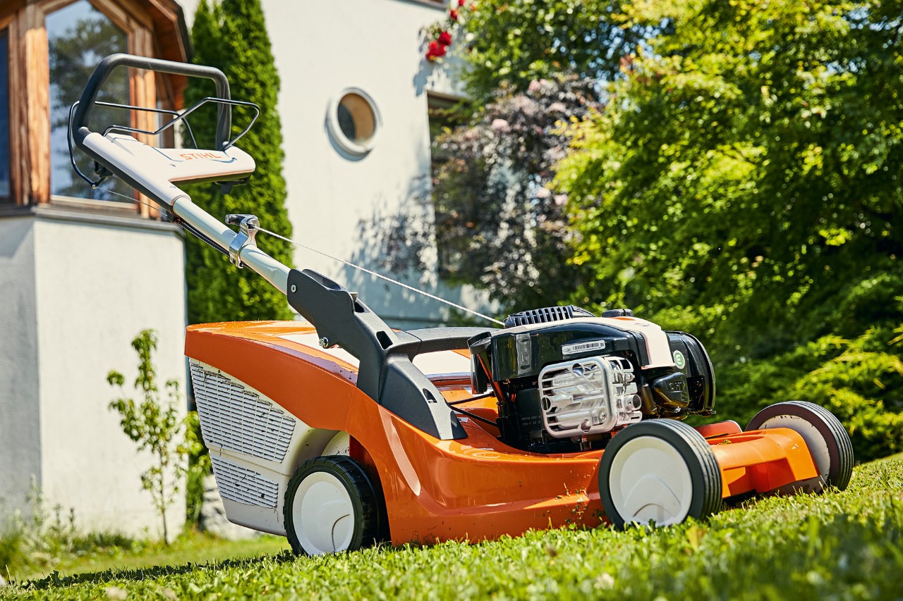 STIHL RM 443 T benzinegrasmaaier op een groen gazon voor een huis 