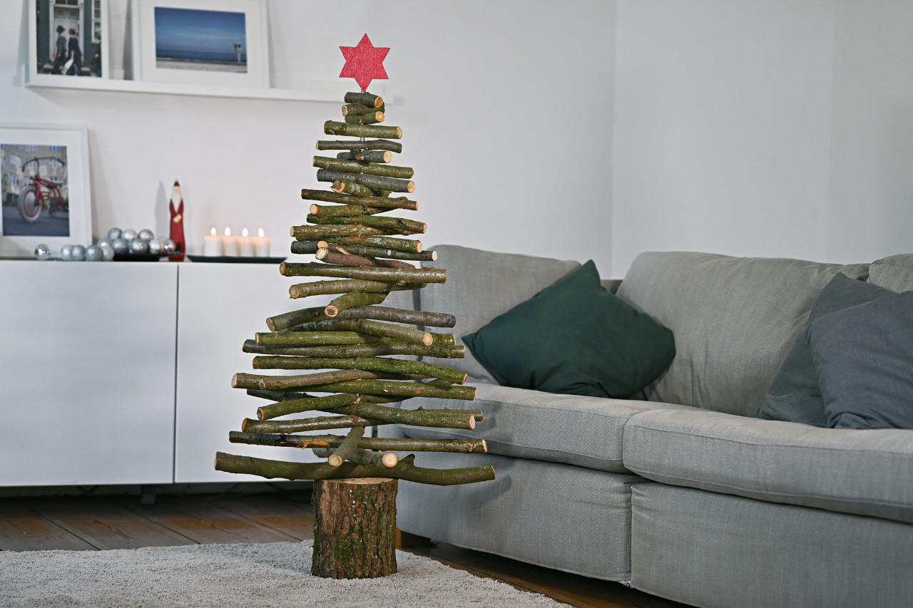 Een zelfgemaakte houten kerstboom in een interieur in kerstsfeer