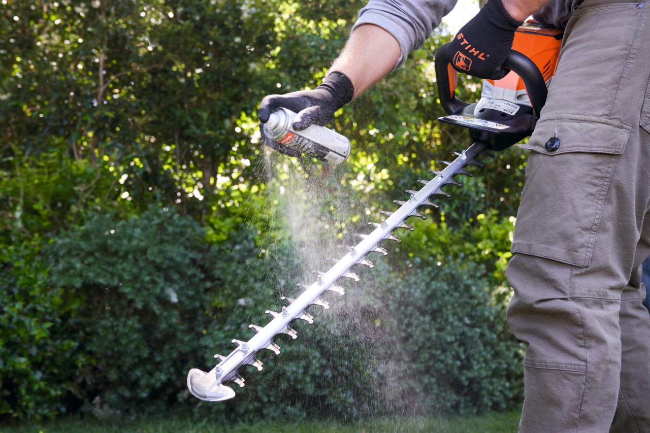 Een man besproeit de STIHL HSA 60 accuheggenschaar met Multiclean